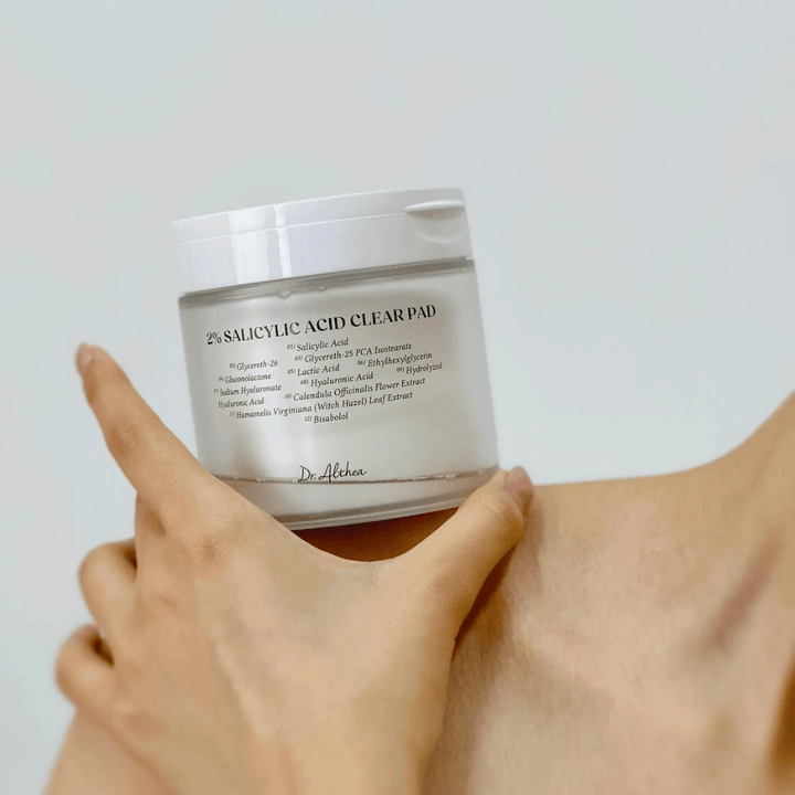 Dr. Althea 2% Salicylic Acid Clear Pad wird in der Hand gehalten. Toner-Pads mit 2% Salicylsäure, die sanft exfolieren, die Haut beruhigen und die Hautstruktur verbessern.