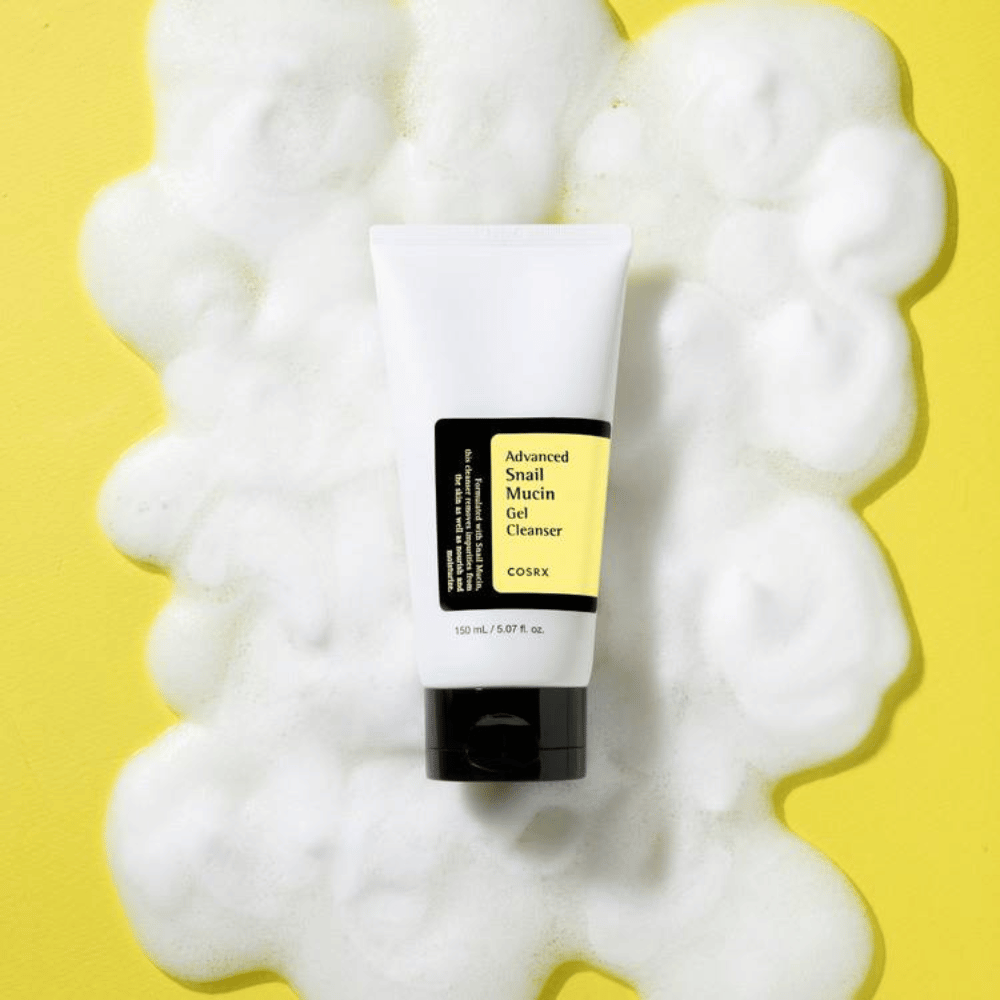 COSRX Advanced Snail Mucin Gel Cleanser 150 ml umgeben von reichlich Schaum auf gelbem Hintergrund – milde koreanische Gesichtsreinigung mit snail mucin für Feuchtigkeit und Strahlkraft.