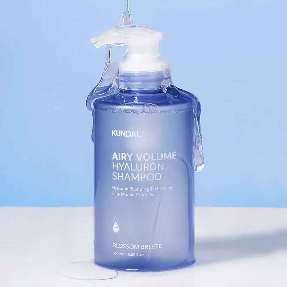KUNDAL Airy Volume Hyaluron Shampoo Blossom Breeze in blauer Pumpflasche, mit Hyaluron und Blue Marine Complex, fotografiert mit fließendem Wasser.