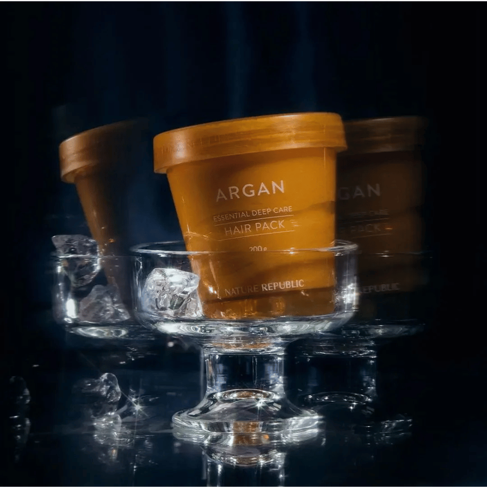 Nature Republic Argan Essential Moisture Repairing Hair Mask auf Glasplatte mit Eiswürfeln platziert – luxuriöse und pflegende Haarmaske.