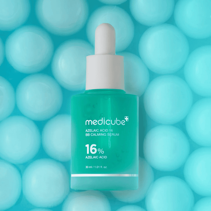 Kampagnenbild von Medicube Azelaic Acid 16 BB Calming Serum vor türkisfarbenem Hintergrund mit weichen Sphären, die Feuchtigkeit, beruhigende Wirkung und ein ebenmäßiges Hautbild symbolisieren.
