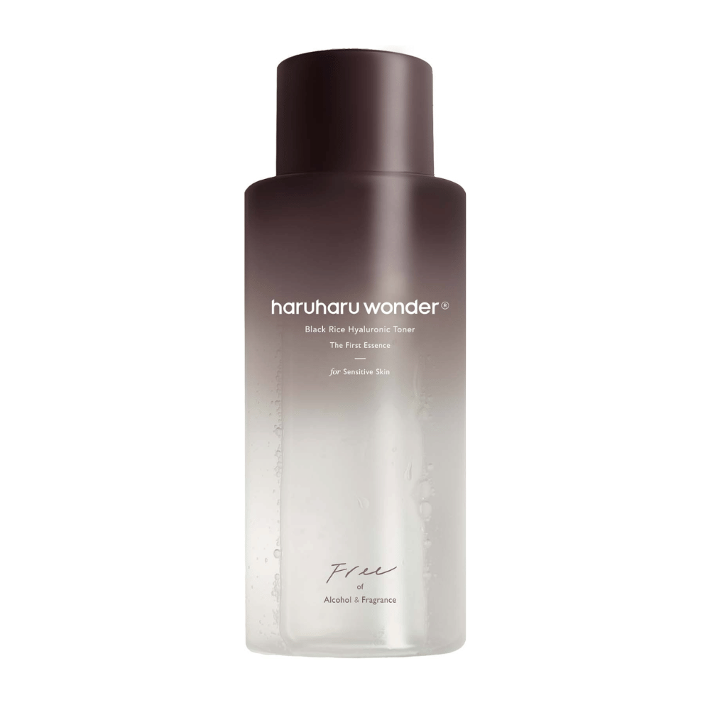 Eine Flasche von haruharu wonder Black Rice Hyaluronic Toner The First Essence, mit dunkelbraunem bis transparentem Farbverlauf und dem Text "Frei von Alkohol & Duftstoffen", auf weißem Hintergrund.