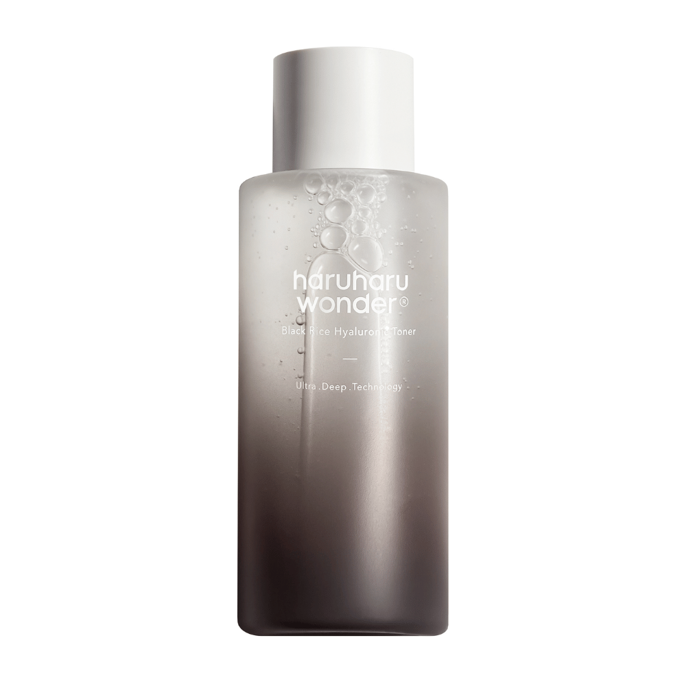 Eine Flasche von haruharu wonder Black Rice Hyaluronic Toner mit einem grauen bis weißen Farbverlauf und Wassertropfen auf der Oberfläche, vor einem weißen Hintergrund.