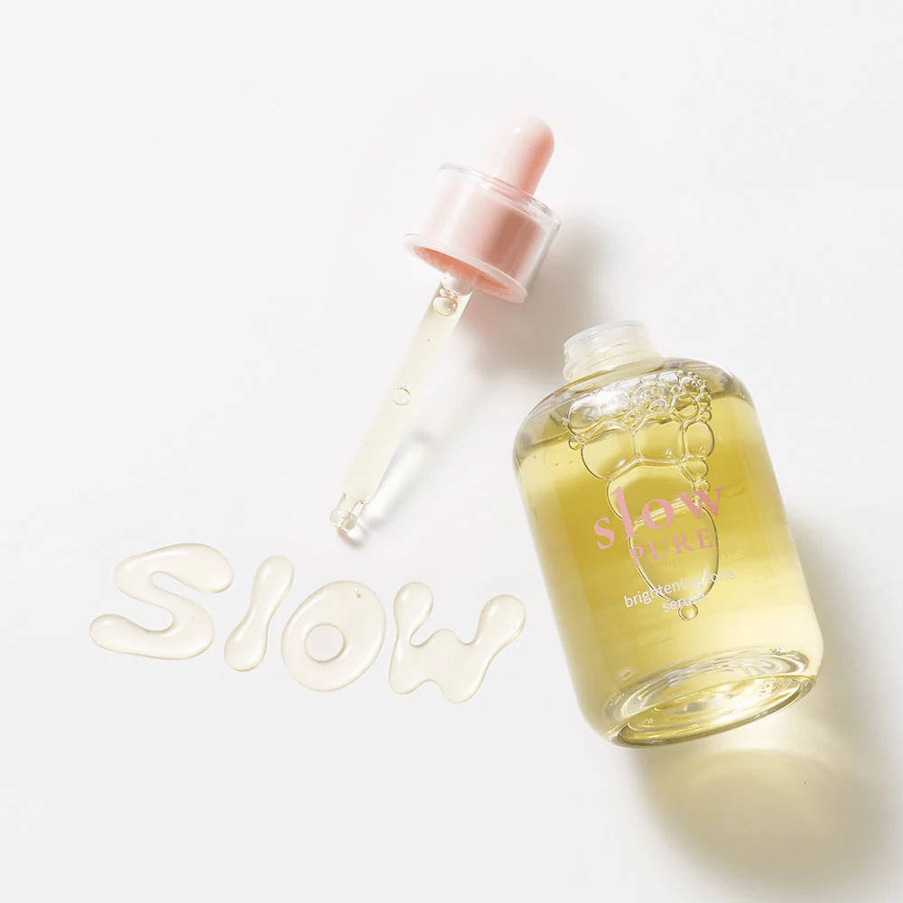 Slow Pure Brightening Tone Serum mit offener Pipette, Text geschrieben im Serum auf der Oberfläche: "Slow".
