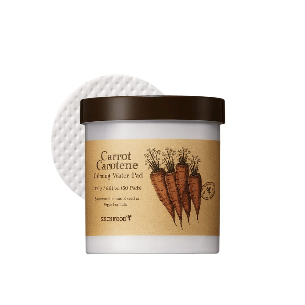 Eine Dose "Carrot Carotene Calming Water Pad" von SKINFOOD. Die Dose enthält 60 Pads und ist mit einem Bild von Karotten versehen. Das Produkt, das auf Karottensamenöl basiert, ist veganfreundlich und entwickelt, um die Haut zu beruhigen.