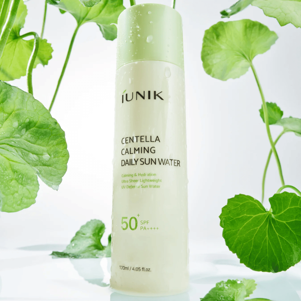 2. iUNIK Centella Calming Daily Sun Water SPF50+ PA++++ – feuchtigkeitsspendender Sonnenschutz mit Centella Asiatica, umgeben von grünen Blättern und Wassertropfen