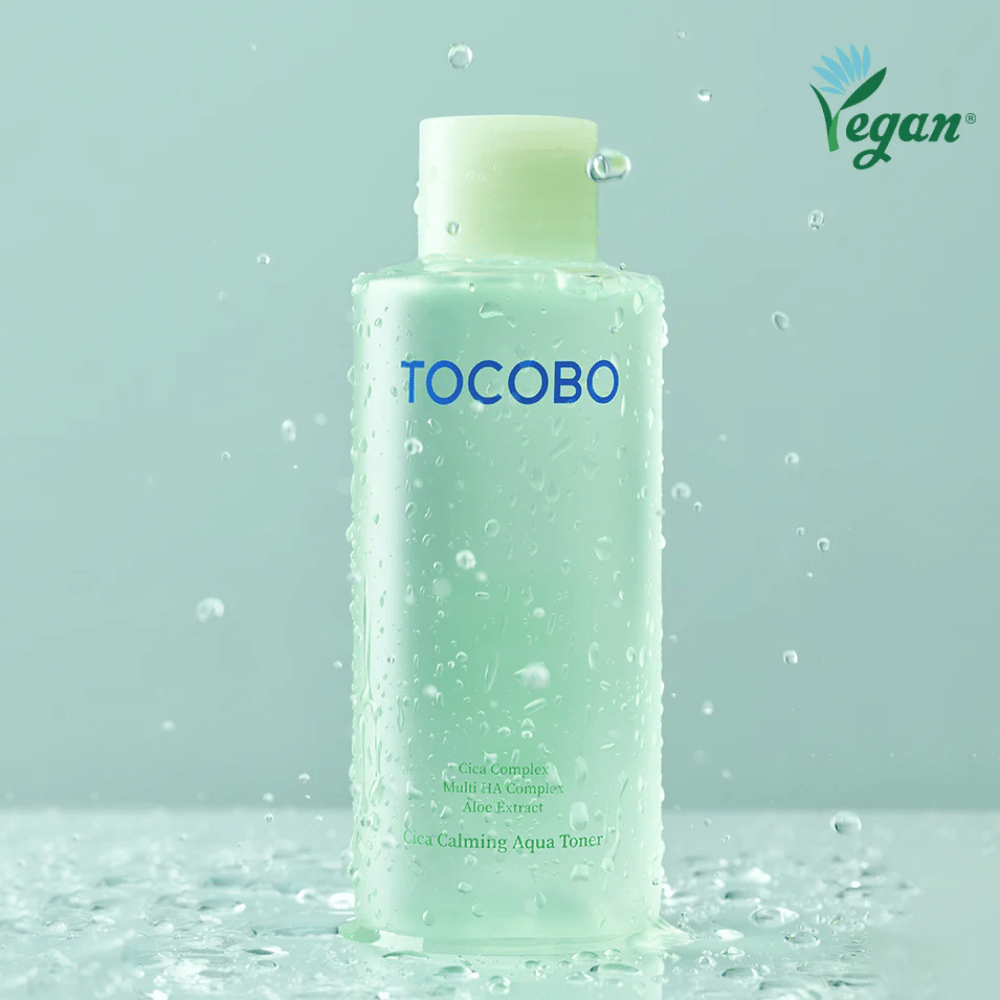 Produktbild von TOCOBO Cica Calming Aqua Toner, umgeben von Wassertropfen, die die feuchtigkeitsspendenden und beruhigenden Eigenschaften des Toners für empfindliche Haut hervorheben.
