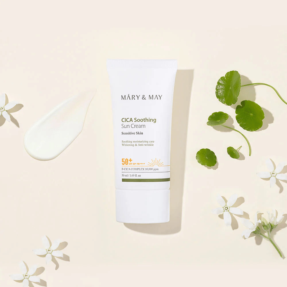 Mary&May CICA Soothing Sun Cream SPF50+ PA++++ präsentiert zusammen mit einer Creme-Textur, Centella-Blättern und weißen Blumen. Das Bild hebt die beruhigenden Eigenschaften des Produkts und den Fokus auf empfindliche Haut hervor.