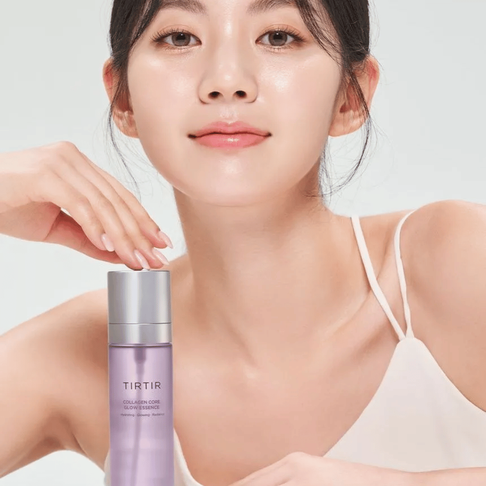 Frau mit strahlender Haut posiert mit TIRTIR Collagen Core Glow Essence – eine strahlende Essenz für festere und mit Feuchtigkeit versorgte Haut.