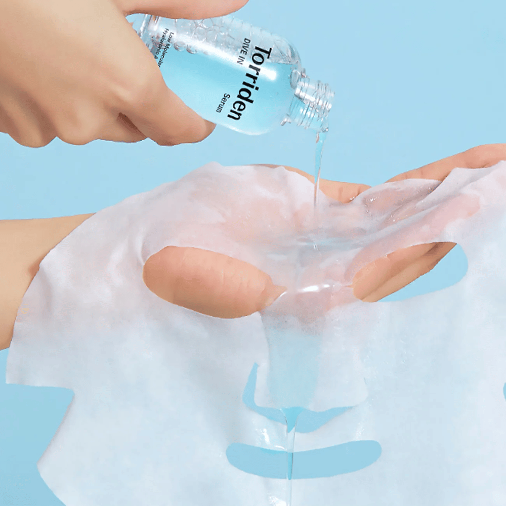 Gesichtsmaske dr mit Lösung aus einer Flasche "Torriden Dive-In", vor blauem Hintergrund.