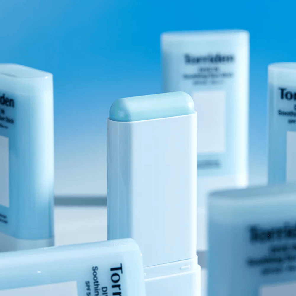Nahaufnahme von Torriden DIVE IN Soothing Sun Stick, die die weiche Sonnenschutzformel im Stickformat mit mehreren Produkten im Hintergrund zeigt.