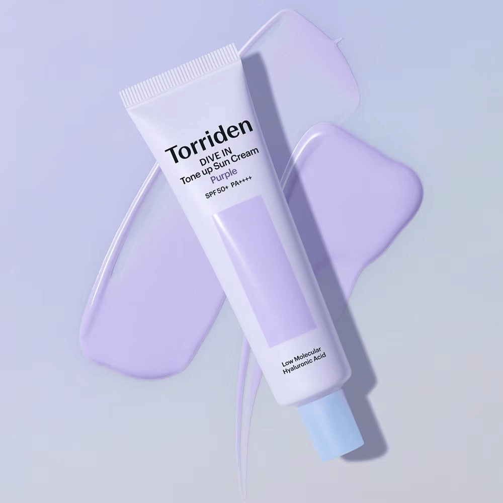 Torriden DIVE IN Tone Up Sun Cream Purple auf verschmierter lila Creme platziert, die den hauttonausgleichenden und strahlenden Effekt hervorhebt.