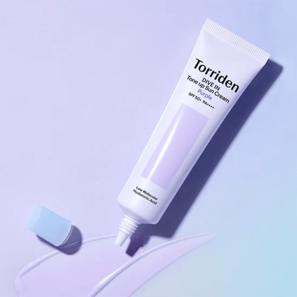 Geöffnete Tube von Torriden DIVE IN Tone Up Sun Cream Purple mit lila getönter Sonnenschutztextur, die die farbkorrigierende Formel des Produkts zeigt.