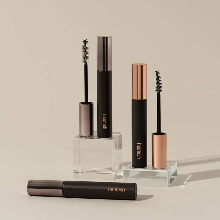 Heimish Dailism Smudge Stop Mascara mit sichtbaren Bürsten, die den Unterschied zwischen Volumen- und Curlingbürste zeigen.