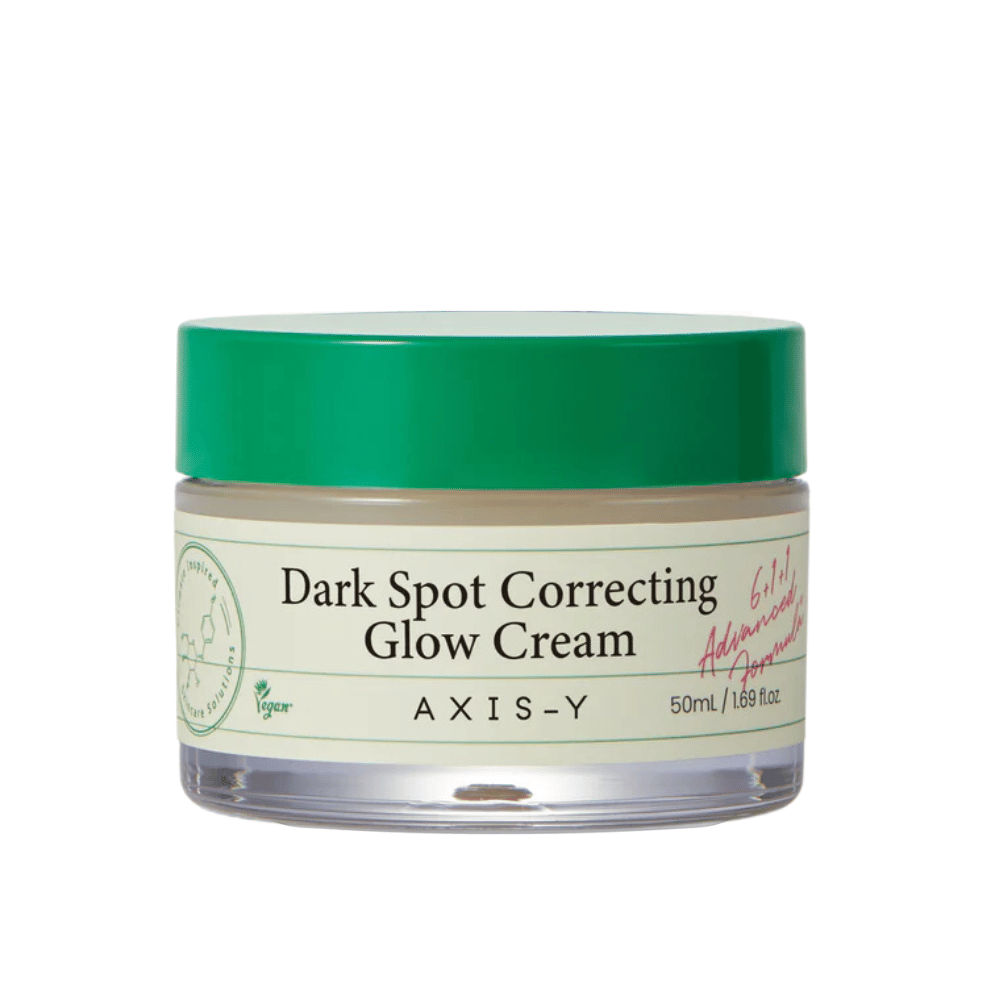 Ein Glas von "AXIS-Y Dark Spot Correcting Glow Cream". Diese Creme ist dazu bestimmt, dunkle Flecken zu korrigieren und der Haut Glanz zu verleihen. Die Verpackung ist elegant mit einem durchsichtigen Boden und einem auffälligen grünen Deckel.