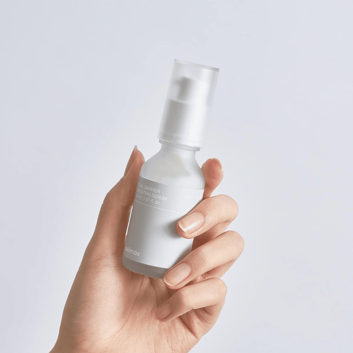 Celimax Dual Barrier Boosting Serum in der Hand, minimalistische Verpackung, die ein barrierestärkendes koreanisches Serum für empfindliche Haut zeigt.