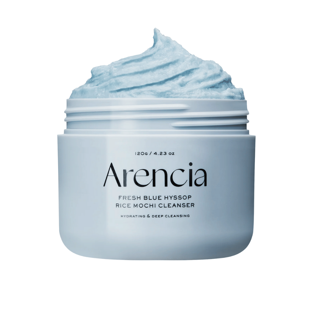 Nahaufnahme eines offenen Glases Arencia Fresh Blue Hyssop Rice Mochi Cleanser. Die blaue Reinigungspaste hat eine luftige, geschlagene Textur und füllt den oberen Teil des Glases.