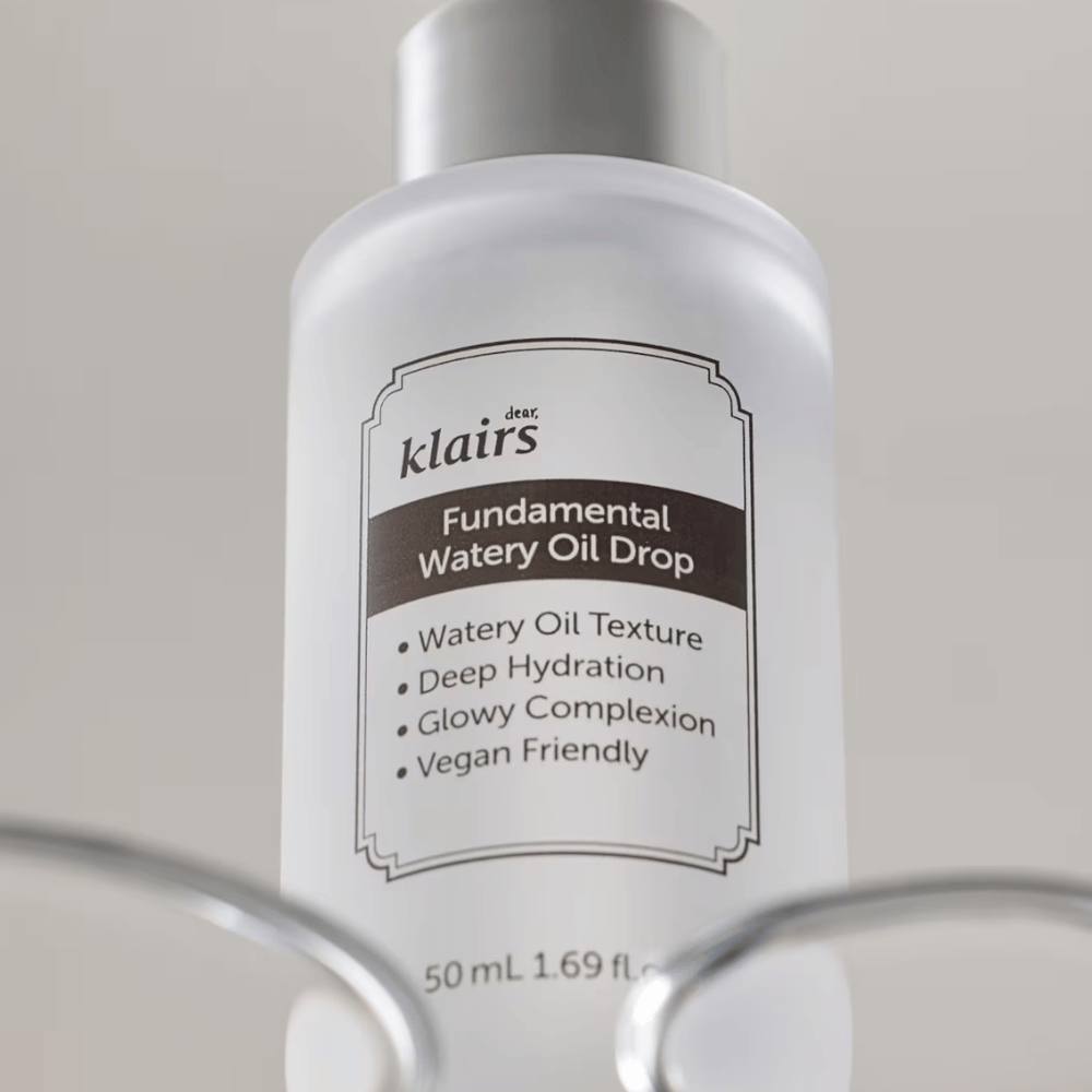 Flasche mit Klairs Fundamental Watery Oil Drop, 50 ml, platziert in einem transparenten Halter, mit einem klaren Etikett, das die feuchtigkeitsspendenden und veganen Eigenschaften des Produkts hervorhebt.
