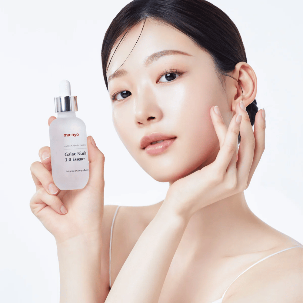 Frau mit strahlender Haut hält Ma:nyo Galac Niacin 3.0 Essence – koreanische Essenz, die einen gleichmäßigeren Hautton und natürlichen Glanz verleiht.