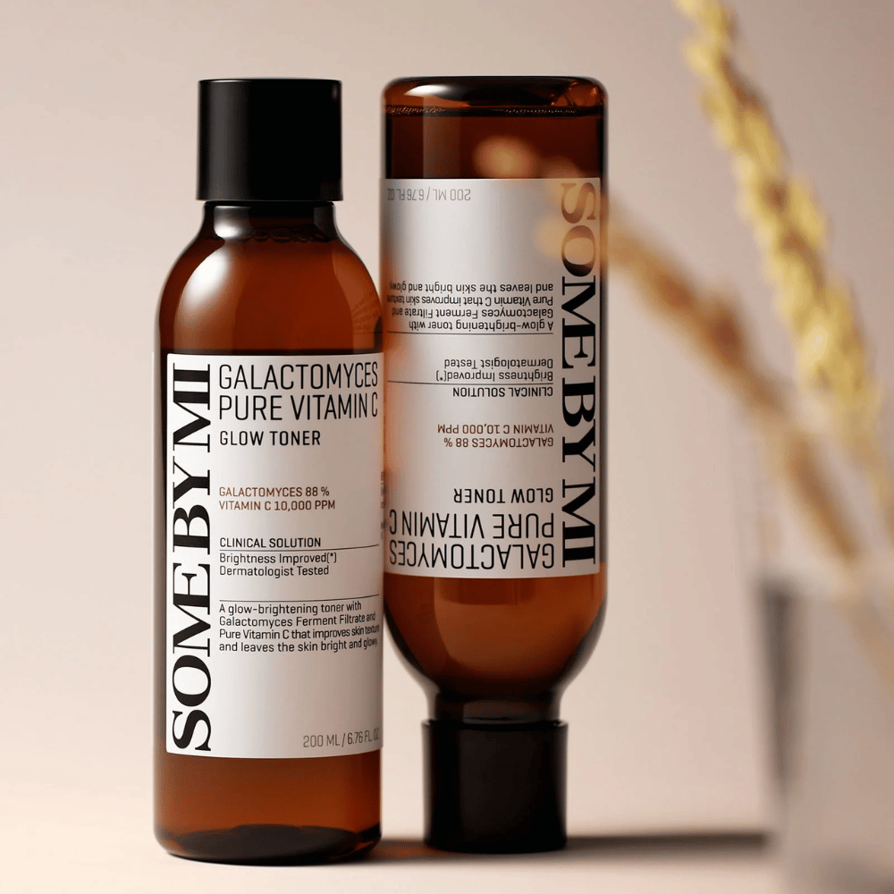 Bild von SOME BY MI Galactomyces Pure Vitamin C Glow Toner. Die Flaschen haben ein stilvolles Design mit braunen Tönen und schwarzem Deckel. Das Produkt enthält 88% Galactomyces und 10.000 ppm Vitamin C, was verspricht, die Hautstrahlung zu verbessern und einen frischeren Hautton zu verleihen.
