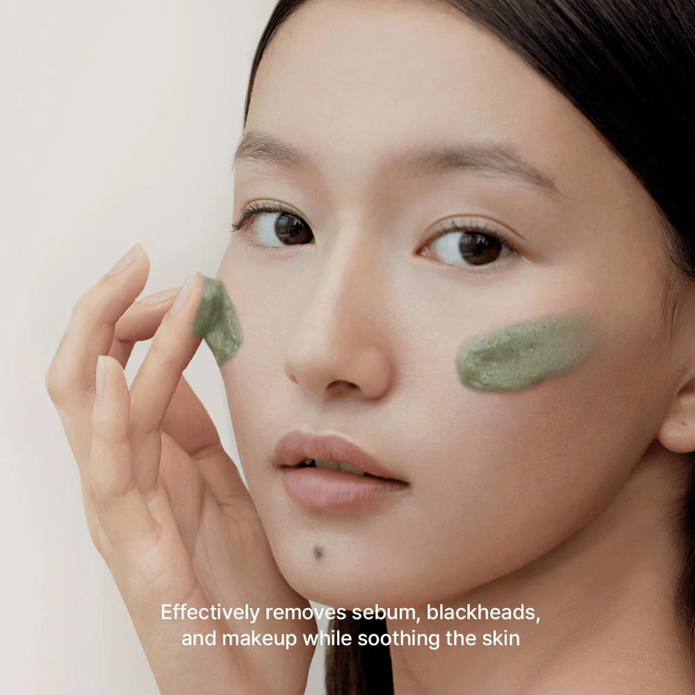 Ein Model trägt den grünen Cleanser auf die Wangen auf, mit Fokus auf die Entfernung von Talg, Mitessern und Make-up, während die Haut gleichzeitig beruhigt wird und sich ausgeglichen anfühlt.