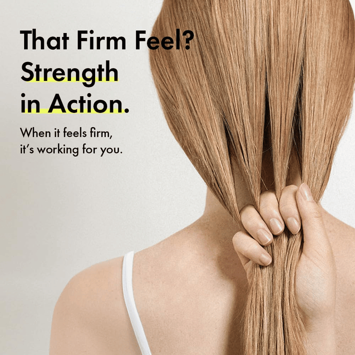 Person hält ihr Haar in der Hand, um stärkere Haarsträhnen und ein festeres Haargefühl nach der Anwendung von Grabity g0.0 Hair Lifting Shampoo Strong zu veranschaulichen.