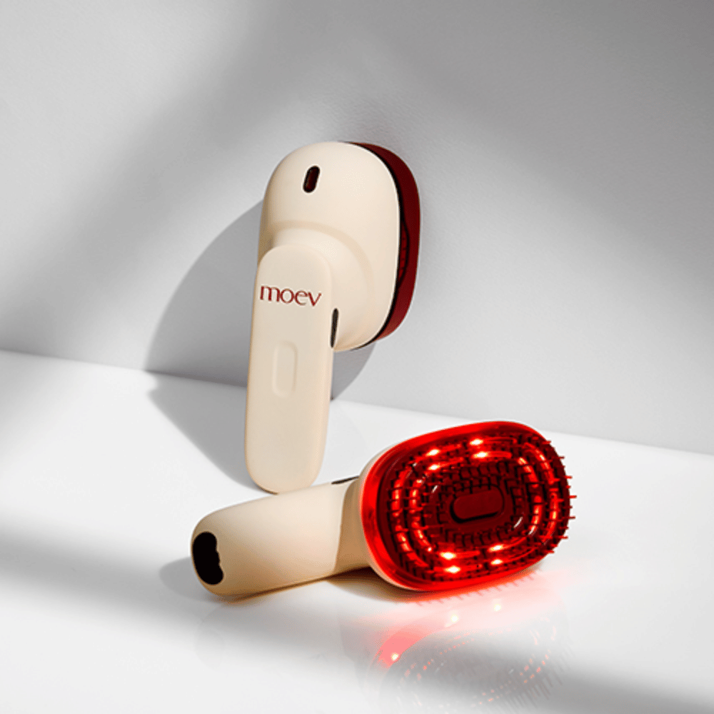 Zwei MOEV Hair Steamer Pro auf weißem Hintergrund. Einer zeigt aktivierte rote LED-Lichter, die die Kopfhaut stimulieren und das Haarwachstum verbessern.