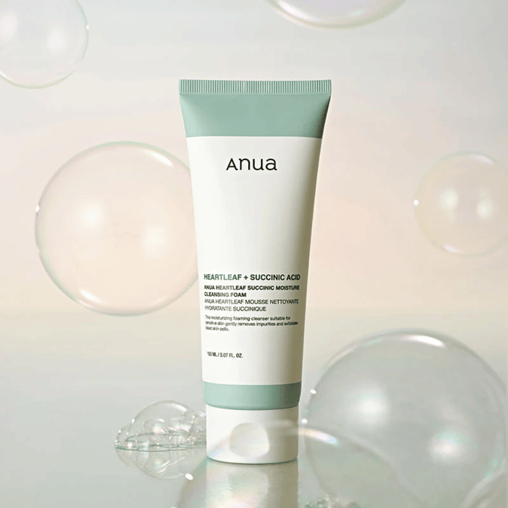Produktbild von Anua Heartleaf + Succinic Acid Moisture Cleansing Foam, umgeben von transparenten Blasen. Das Bild verstärkt das Gefühl von sanfter Reinigung, Frische und luftigem Schaum.