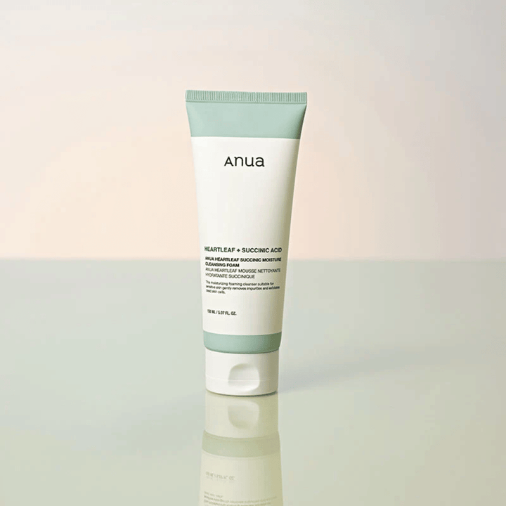 Freistehendes Produktbild von Anua Heartleaf + Succinic Acid Moisture Cleansing Foam. Das Produkt wird auf einer reflektierenden Oberfläche stehend gezeigt, die das Design der Verpackung und die stilvolle Ästhetik der Marke deutlich hervorhebt.