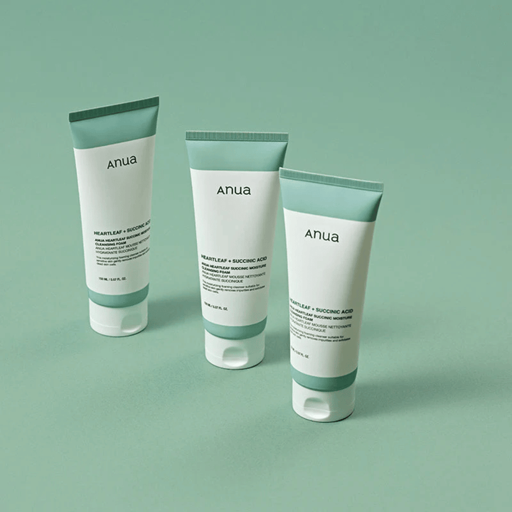 Drei Verpackungen von Anua Heartleaf + Succinic Acid Moisture Cleansing Foam, präsentiert vor einem hellgrünen Hintergrund. Das Bild hebt das klare und minimalistische Design des Produkts hervor und vermittelt einen professionellen Eindruck der Produktserie.