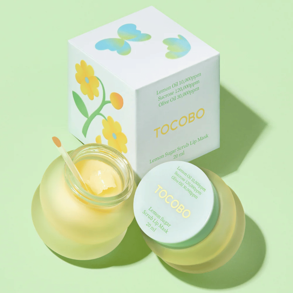 Tocobo Lemon Sugar Scrub Lip Mask zusammen mit ihrer Verpackung mit Blumendesign auf einem hellgrünen Hintergrund.