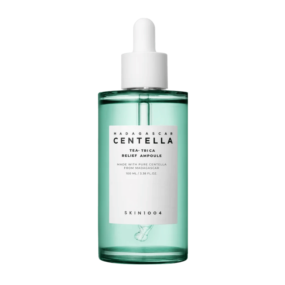 Grüne durchsichtige Flasche mit weißem Etikett und Pipette – SKIN1004 Madagascar Centella Tea-Trica Relief Ampoule 100 ml vor weißem Hintergrund.