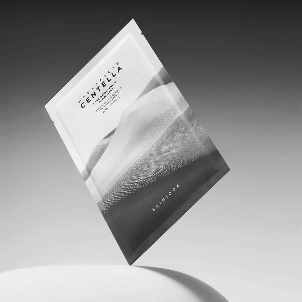 Sheet mask-Verpackung von SKIN1004, schwebend vor grauem Hintergrund mit minimalistischem Design.