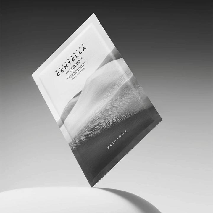 Sheet mask-Verpackung von SKIN1004, schwebend vor grauem Hintergrund mit minimalistischem Design.
