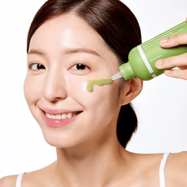Person, die Centellian24 Madeca Matcha Toning Peeling Gel aufträgt – sanftes Peeling, das hilft, abgestorbene Hautzellen zu entfernen und die Haut weicher und strahlender zu machen.