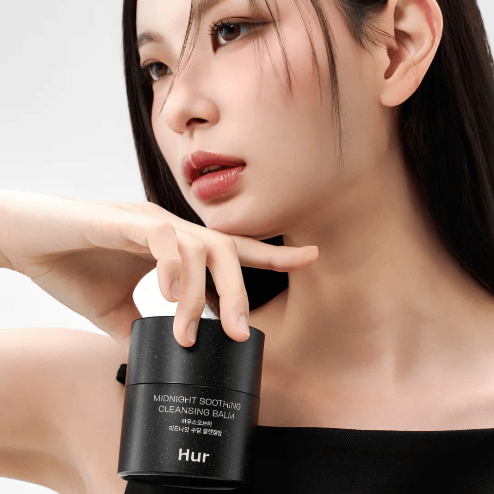 Modell hält Wie Midnight Soothing Cleansing Balm. Koreanischer Reinigungsbalsam, der effektiv Make-up entfernt und die Haut ohne Reizung reinigt.