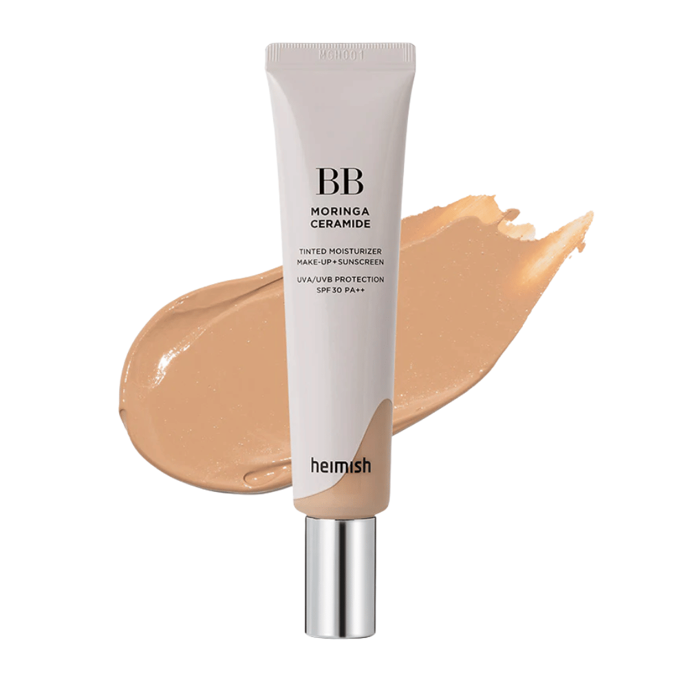 Produktbild von Heimish Moringa Ceramide BB Cream vor einem Strich beigefarbener BB-Creme. Das Bild hebt einen mittel-dunklen Farbton sowie die feuchtigkeitsspendenden und ausgleichenden Eigenschaften des Produkts hervor.