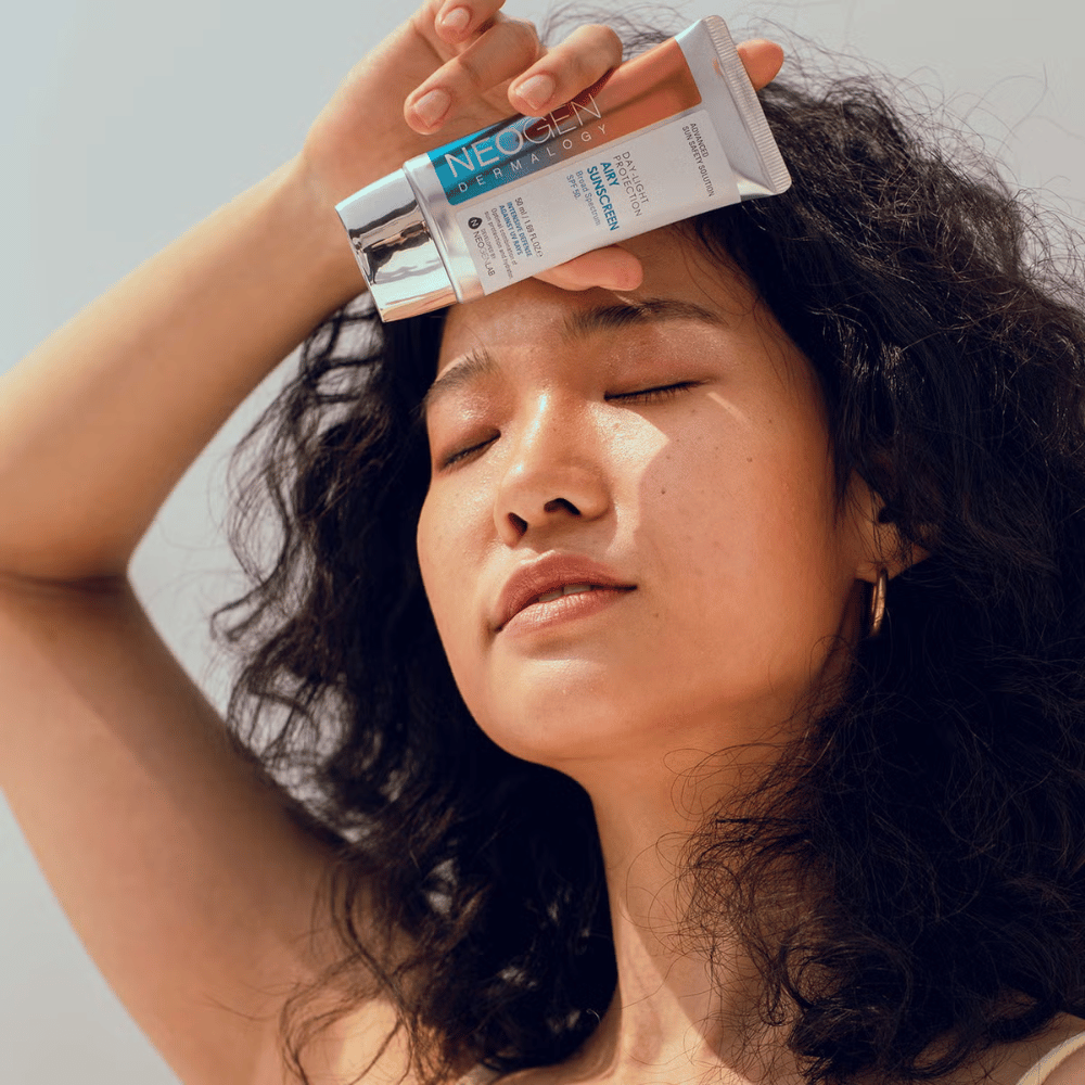 Neogen Dermalogy Day-Light Protection Airy Sunscreen SPF50 50ml – leichte Sonnencreme mit Breitbandspektrum UV-Schutz, gezeigt in der Anwendung im Sonnenlicht.