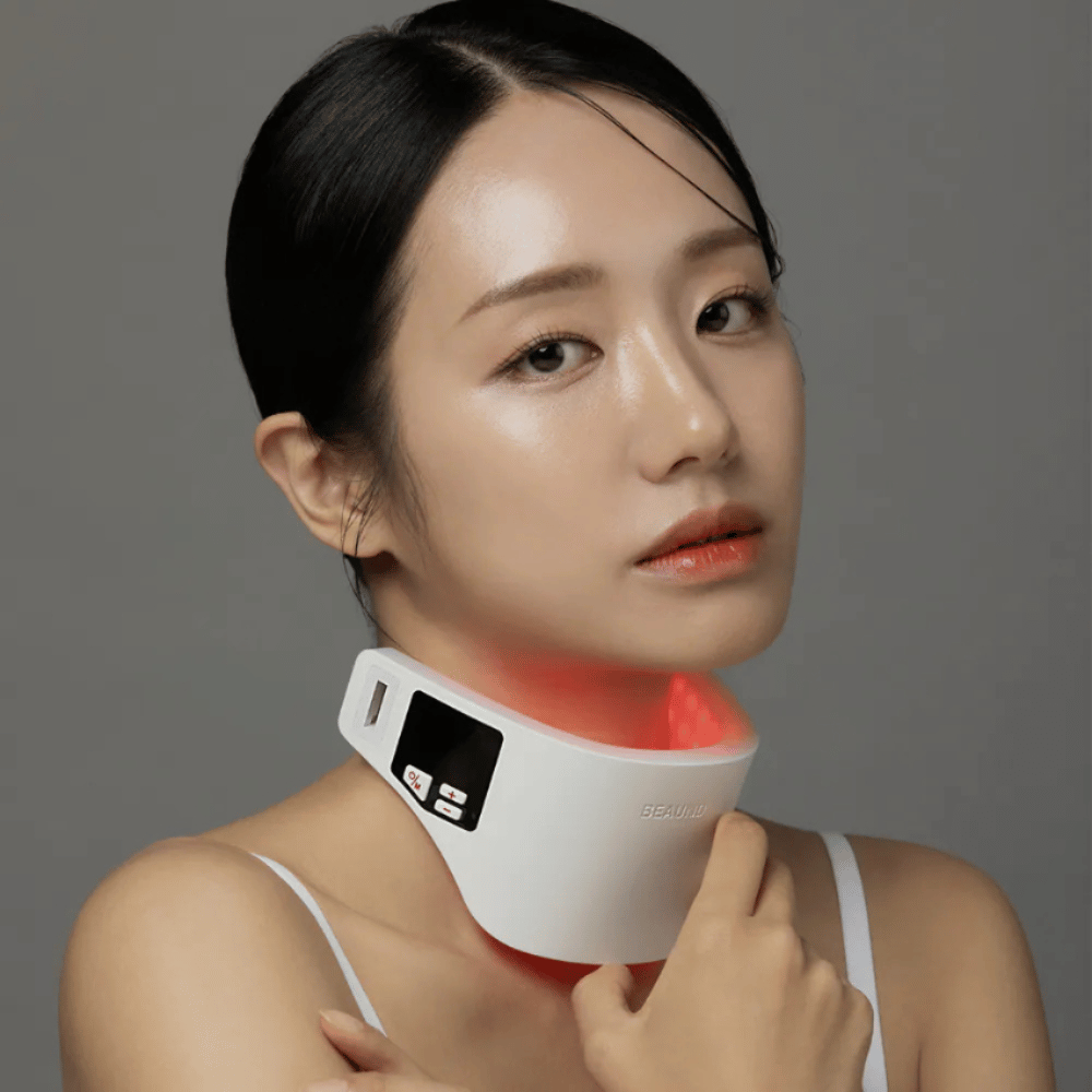 Ein Modell trägt Beaund Neckcera um den Hals. Die rote LED-Beleuchtung veranschaulicht die aktive Behandlung, während das Gerät bequem auf der Haut sitzt.