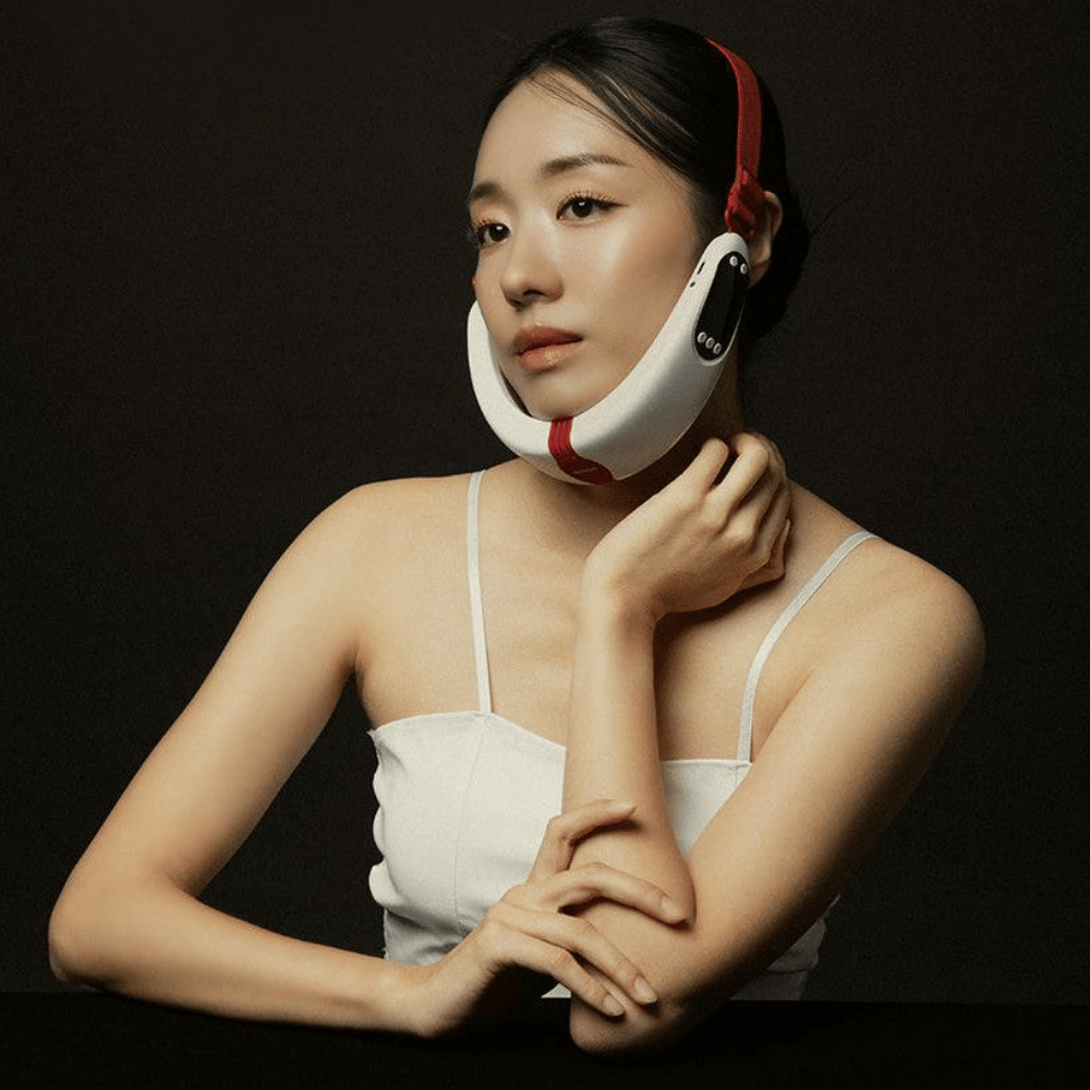 Ein Model verwendet Beaund Nmode Pro um die Kieferlinie und das Kinn. Das Bild veranschaulicht, wie das Gerät während der Behandlung an Ort und Stelle sitzt und für den Gesichts- und Kieferbereich angepasst ist.