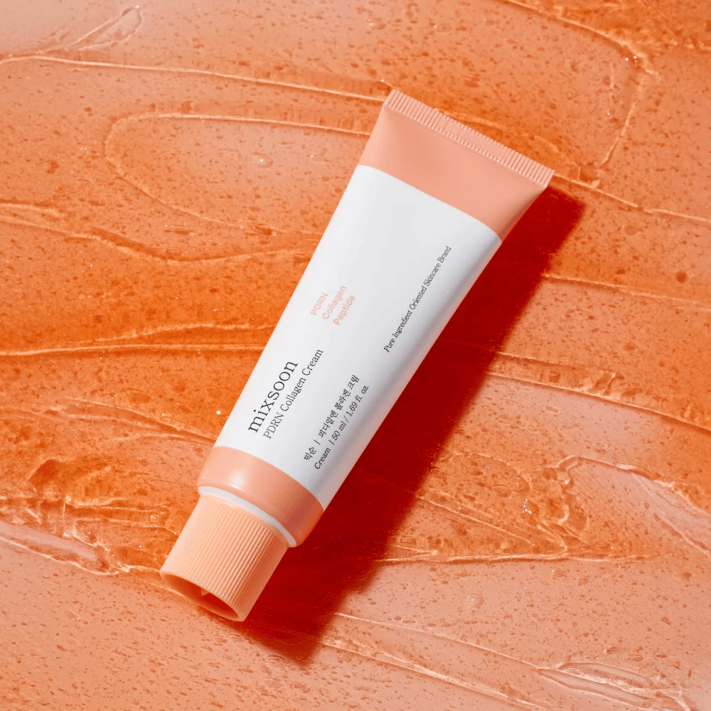 Mixsoon PDRN Collagen Cream liegt auf einem glänzenden orangefarbenen Hintergrund. Eine nährende Gesichtscreme mit PDRN, Kollagen und Peptiden für straffere Haut.