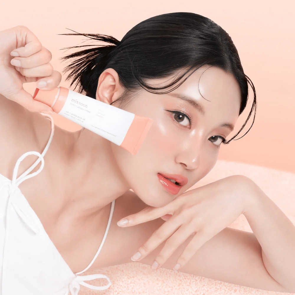 Person mit strahlender Haut hält Mixsoon PDRN Collagen Cream nahe der Wange. Die Creme spendet Feuchtigkeit, stärkt die Elastizität und verleiht einen frischen Glow.