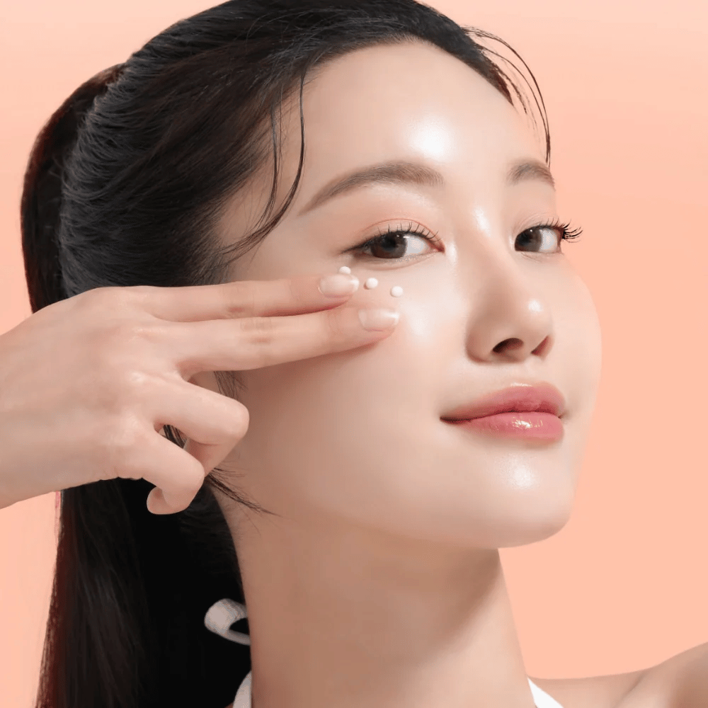Person trägt Mixsoon PDRN Collagen Eye Serum unter den Augen auf. Das Serum hellt auf, reduziert Schwellungen und stärkt die Festigkeit der Haut.
