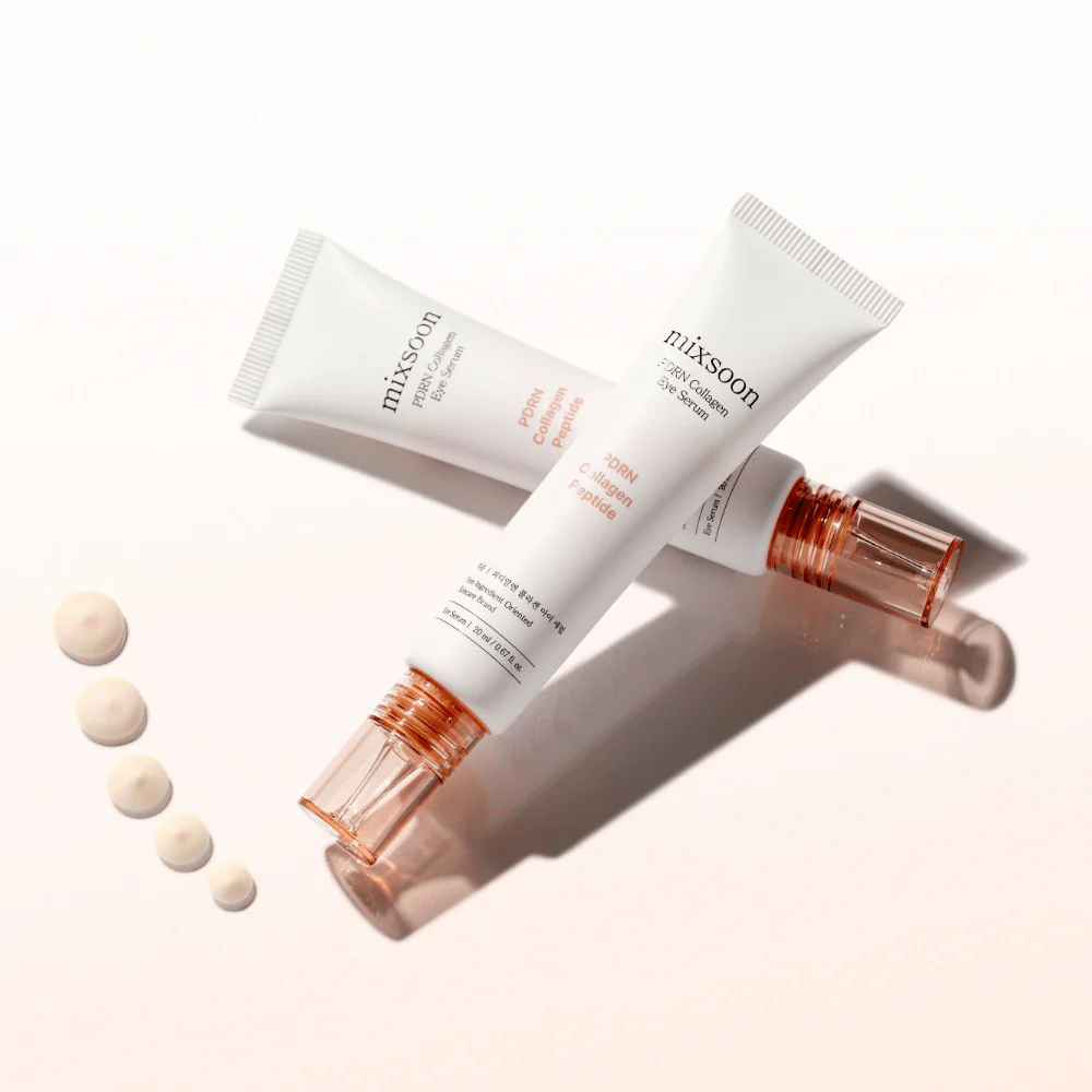 Zwei Tuben von Mixsoon PDRN Collagen Eye Serum liegen gekreuzt mit kleinen Tropfen des Serums. Eine leichte Augenbehandlung, die Feuchtigkeit spendet und Linien glättet.
