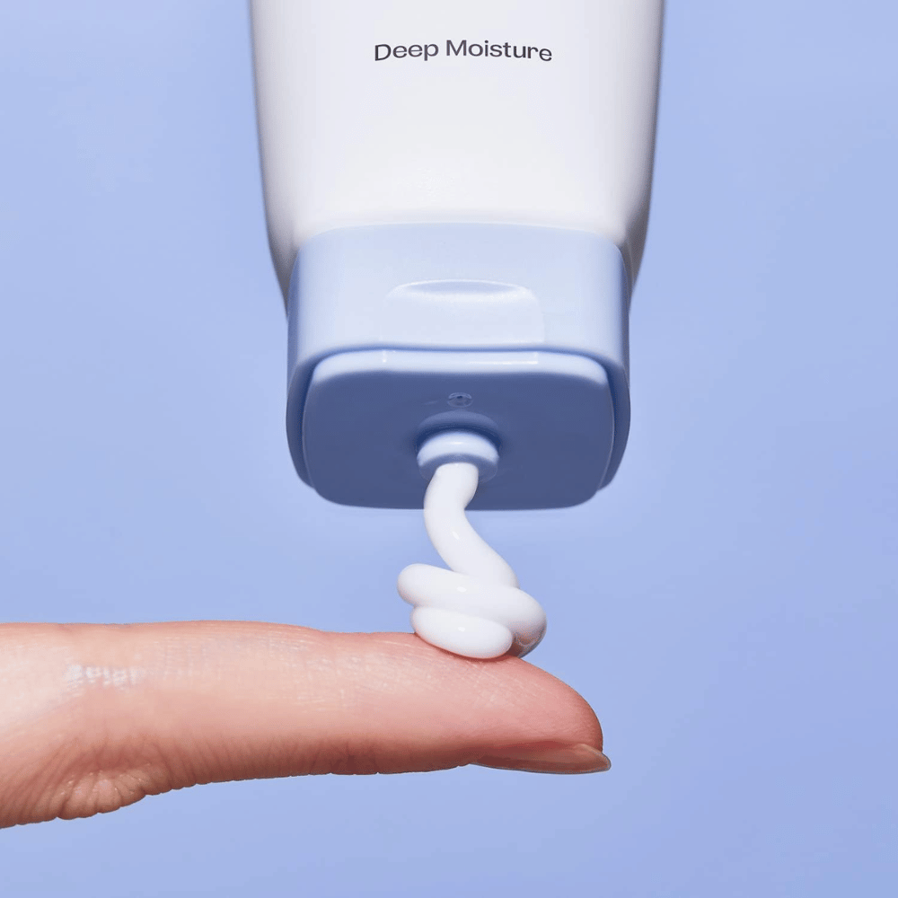 1. Ma:nyo Panthetoin Cream – Nahaufnahme von weißer feuchtigkeitsspendender Gesichtscreme, die aus einer hellblauen Tube auf einen Finger aufgetragen wird