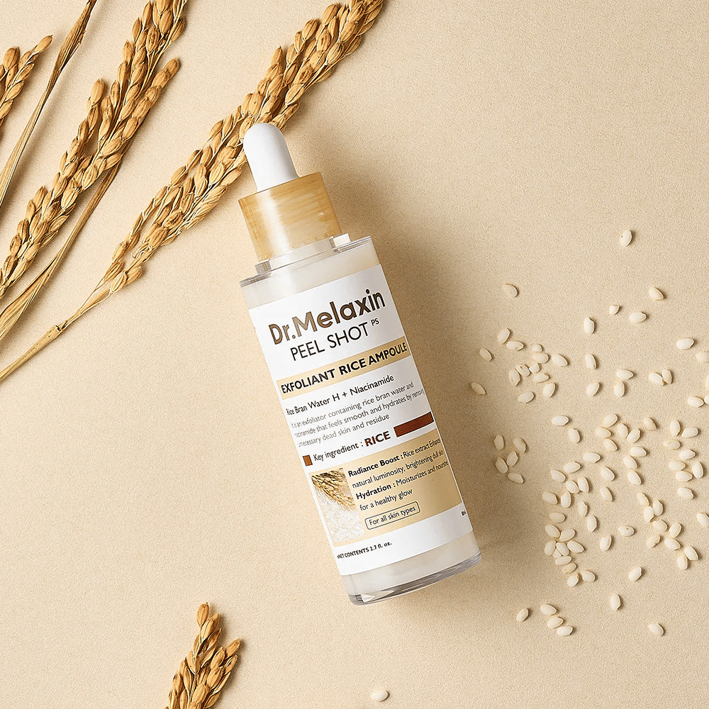 Dr.Melaxin Peel Shot Rice Ampoule liegend auf sandfarbener Oberfläche mit Reis und Ähren, exfolierende Gesichtsampulle, die sanftes Peeling mit intensiver Feuchtigkeit kombiniert.