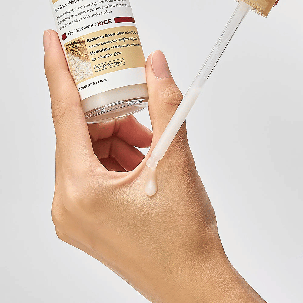 Nahaufnahme von Dr.Melaxin Peel Shot Rice Ampoule, aufgetragen mit Pipette auf die Hand, leicht fließende exfolierende Ampulle, die schnell absorbiert und hydratisierte, glatte Haut hinterlässt.