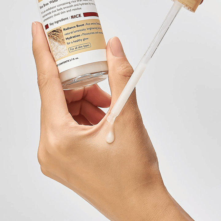 Nahaufnahme von Dr.Melaxin Peel Shot Rice Ampoule, aufgetragen mit Pipette auf die Hand, leicht fließende exfolierende Ampulle, die schnell absorbiert und hydratisierte, glatte Haut hinterlässt.