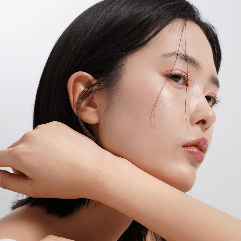Nahaufnahme einer Frau mit gleichmäßiger, strahlender Haut und natürlichem Glow. Perfekte Hautpflege-Inspiration für eine gesunde und mit Feuchtigkeit versorgte Haut.