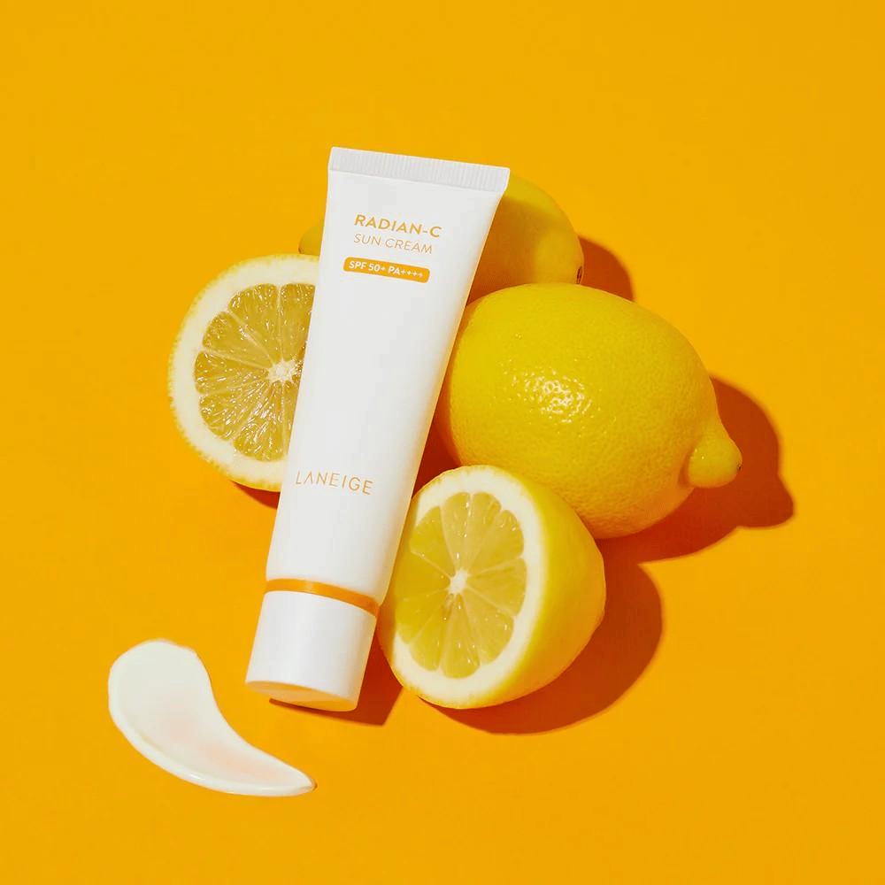 LANEIGE Radian-C Sun Cream SPF 50+ PA++++ mit Zitronen und einem Klecks Sonnencreme auf einem farbenfrohen gelben Hintergrund.